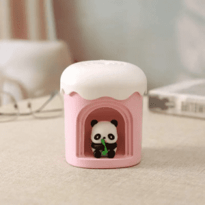 Cute pink cupcake container with a panda figurine, perfect for home or office decor.