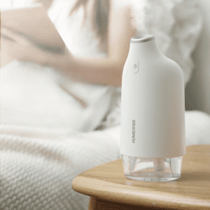 Modern white humidifier on bedside table, enhancing relaxation and air quality in a cozy room.